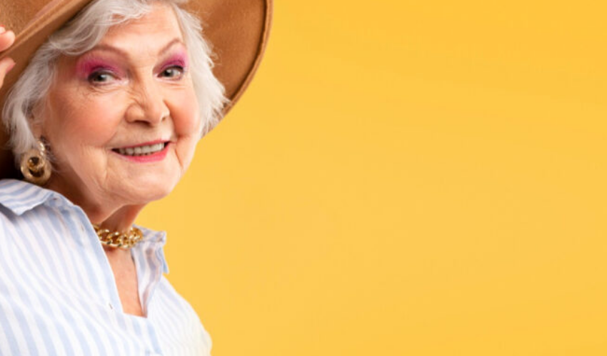 na żółtym tle starsza kobieta w kapeluszu