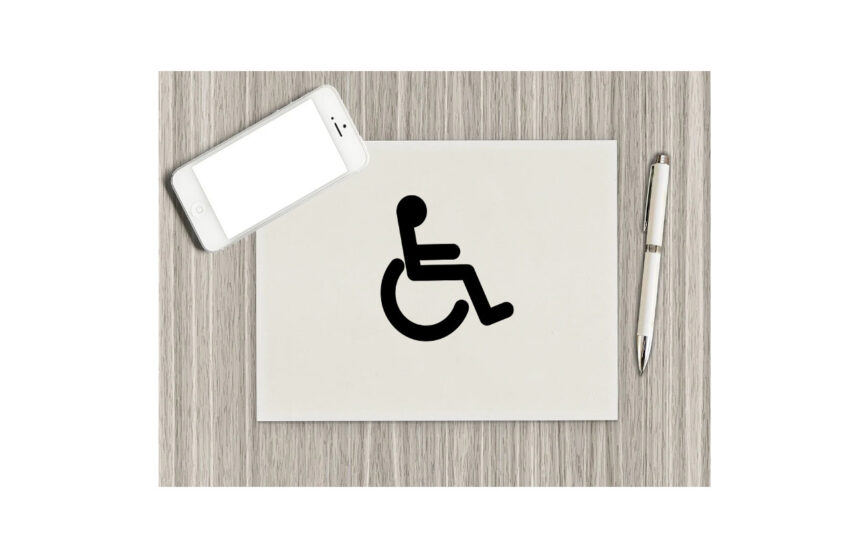 na szarym tle biała kartka ze znakiem inwalidy po prawo długopis po lewo na górze tel.